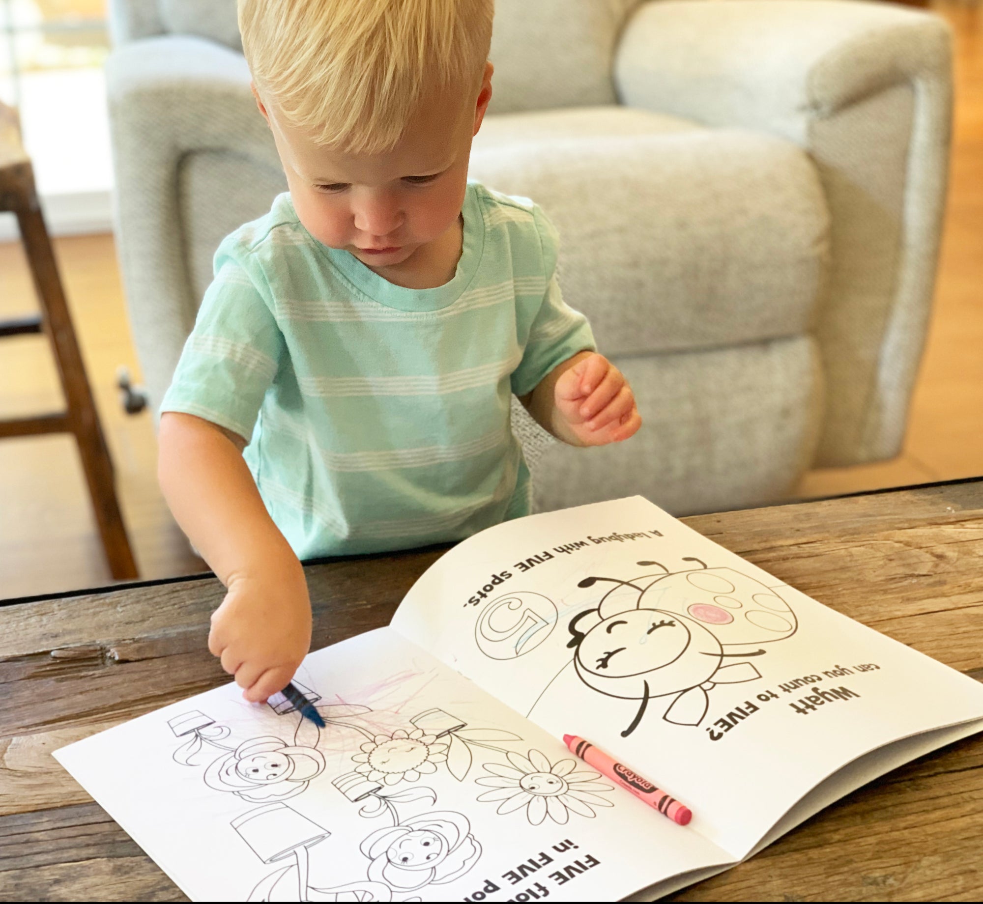 Toddler coloring in personalized coloring book.